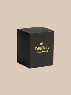 A black cube box with gold N°1 LAGENCE Suède et Santal text, set on beige, hints at luxe sandalwood notes and is crafted from premium soy-blend wax.