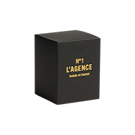 A black box featuring gold text that reads “Suède et Santal” on the front is displayed against a plain white background, highlighting its luxurious sandalwood candle made from a soy-blend wax.