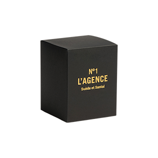 A black, cube-shaped box with gold text reading Suède et Santal on the front, set against a plain white background, reveals a soy-blend wax candle inspired by Tuscan leather and hand-poured in Southern California.