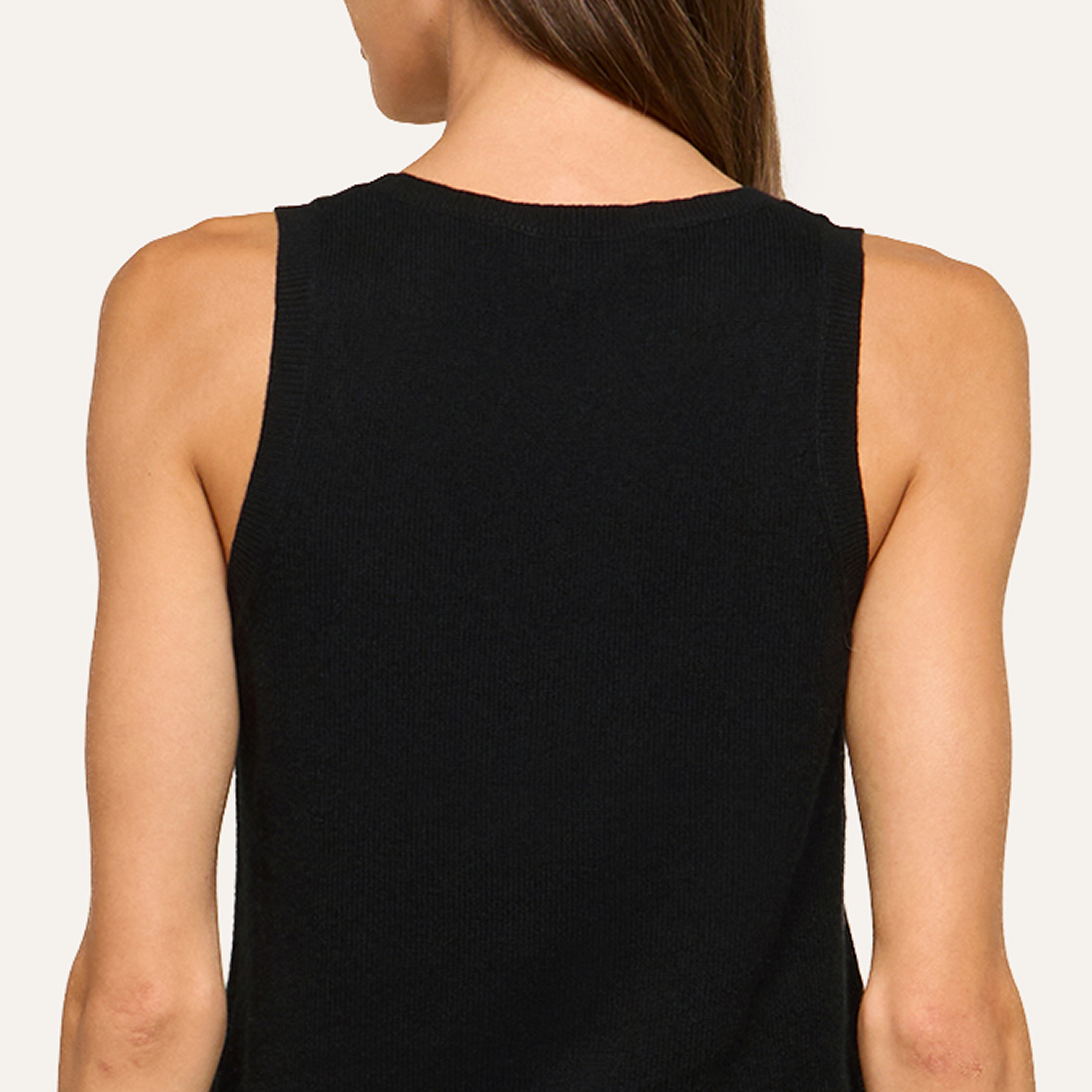 A woman with straight brown hair is shown from the back, wearing a sleeveless black top against a plain, minimalist light-colored background.