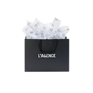 Large L’AGENCE Gift Bag with black ribbon handles and branded tissue paper overflowing from the top.