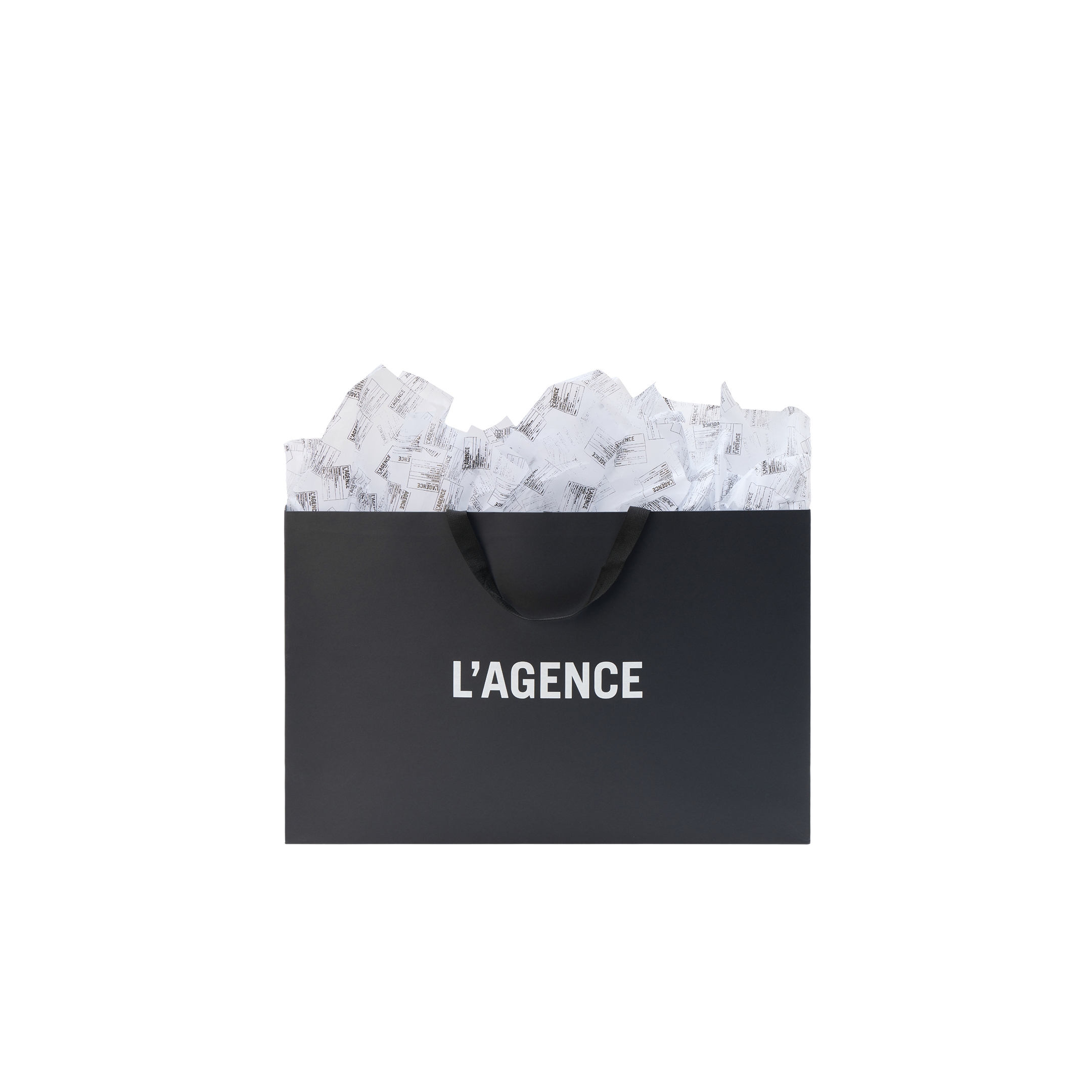 Black L’AGENCE Gift Bag with tissue paper spilling out of the top.