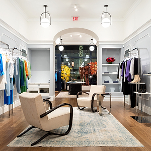 Modern interior design showroom with furniture and clothing displays.