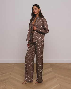 Video of Women in Brown shirt with white polka dot pattern shirt and pant.