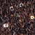 A close-up view of dark, textured soil with several small, sprouting green seedlings.