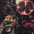 A dark still life composition featuring a halved pomegranate and a decorative gold ornament.