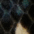 Primo piano di una pelle di serpente scura, con motivi a diamante e sfumature di nero, blu e crema.