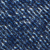 Close-up view of blue denim fabric, showing a diagonal weave pattern with various shades of blue and white threads.