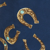 Gold horseshoes with turquoise accents are scattered on a dark blue background.
