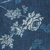 White floral pattern on a textured dark blue background, featuring detailed flowers and leaves.