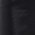 A close-up view of dark, textured fabric with subtle light reflections and folds, showing fine details of the material’s weave and surface.