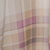 Close-up of a plaid fabric pattern in shades of beige, cream, and muted purple.