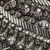 Close-up of intricate metallic beadwork, crystals, and sequins arranged in linear and ornate patterns.