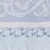 Close-up of a light blue and white fabric with intricate embroidered patterns and decorative stitching.