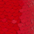 Close-up of overlapping, shiny red sequins creating a textured, fish-scale-like pattern. The sequins reflect light, resulting in varied shades of red across the surface.