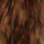 Close-up of brown and black animal fur with a soft, slightly wavy texture. The image shows various shades of brown with darker streaks, giving a natural, mottled appearance.