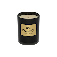 A hand-poured Ambre Soleil candle, featuring a black jar with a gold label that reads Nº 3 LAGENCE and filled with light-colored, unused soy-blend wax. This elegant candle brings sophistication to your space and provides a long-lasting burn for extended enjoyment.