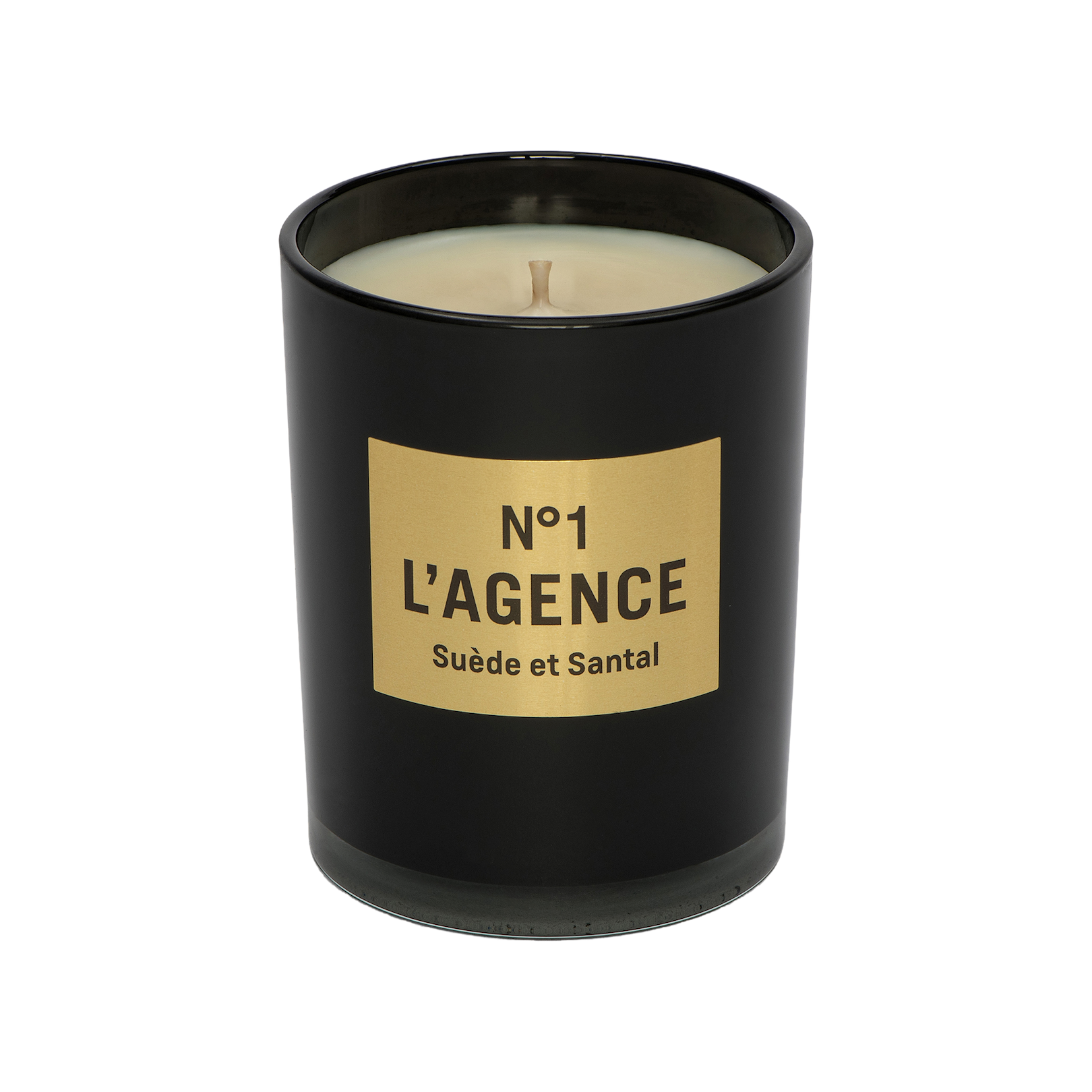 A black candle jar with a gold rectangular label reading “Suède et Santal,” featuring a single wick and hand-poured soy wax, is photographed on a white background.