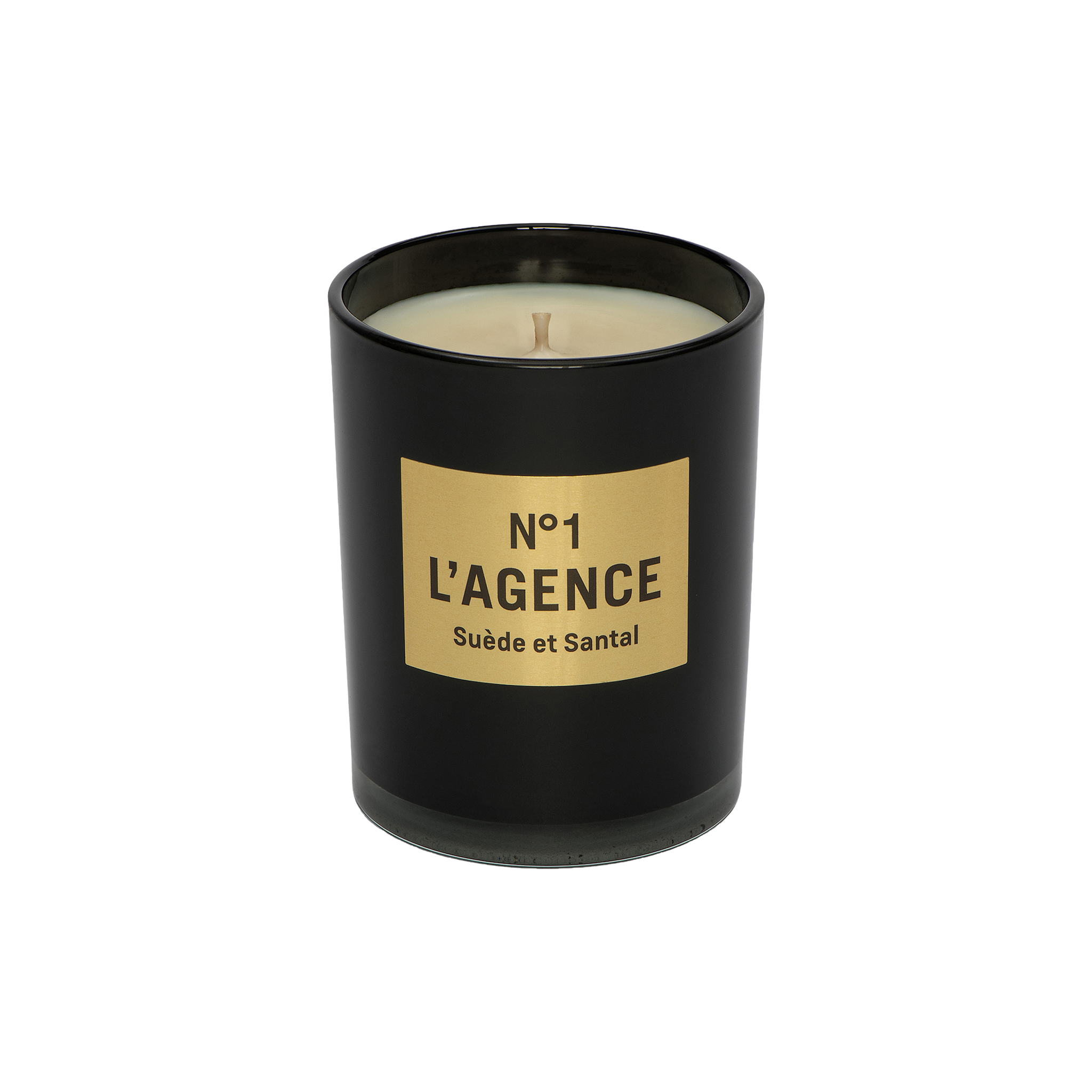 A black candle jar labeled Suède et Santal, adorned with a tan rectangular label and an unlit wick, is displayed against a plain white background. This elegant candle is crafted from a soy-blend wax and features the sophisticated scent of sandalwood.