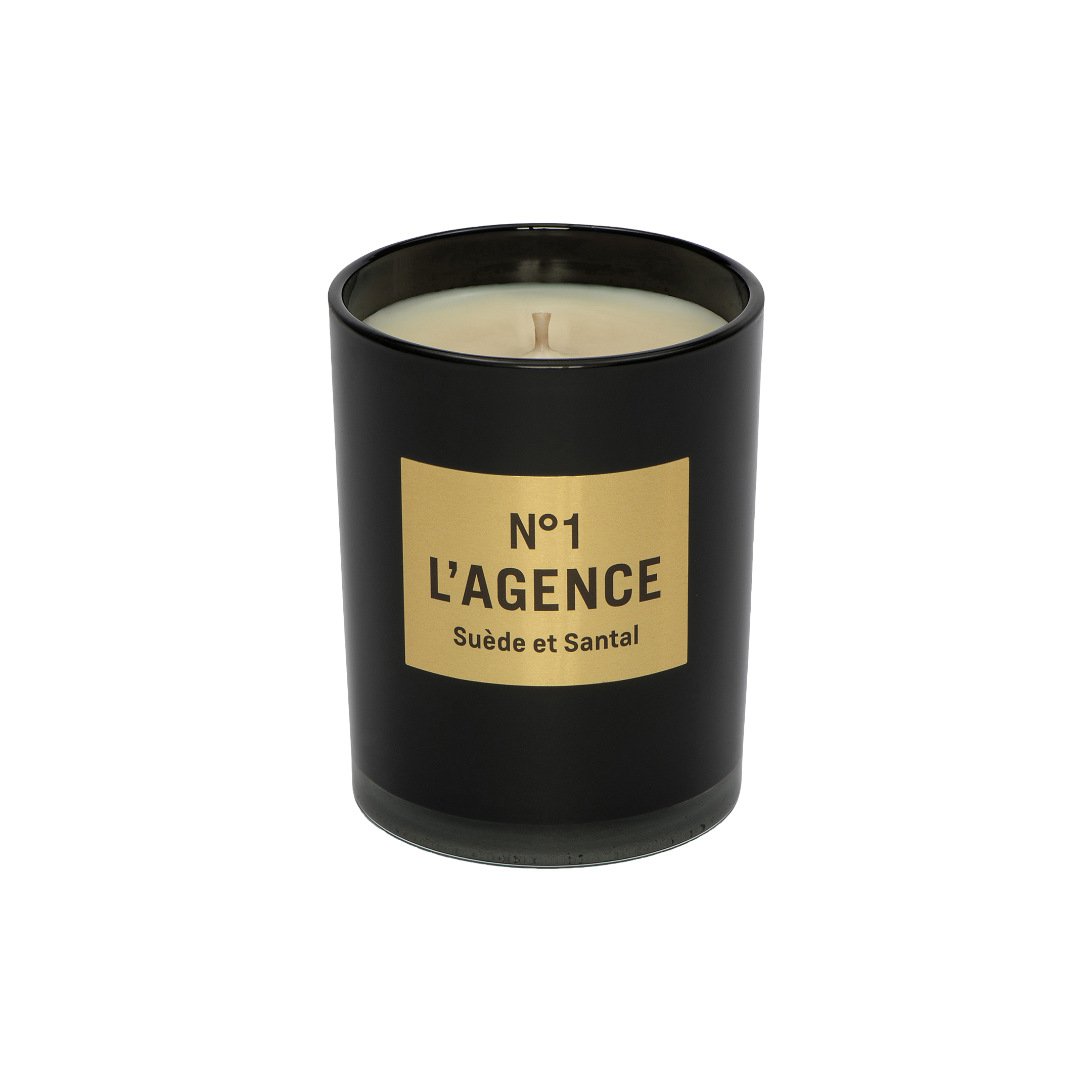 A black candle jar labeled Suède et Santal, adorned with a tan rectangular label and an unlit wick, is displayed against a plain white background. This elegant candle is crafted from a soy-blend wax and features the sophisticated scent of sandalwood.