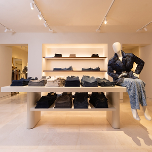 Display of clothing in a store with a mannequin wearing a denim outfit.