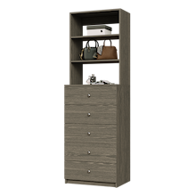Grey closet drawer unit with slab fronts and top surface for jewelry or accessory storage.