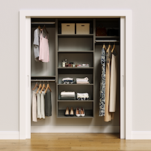 Grey 64.5-inch woodgrain Vista Total Closet Kit, front view in a reach-in closet, holding dresses