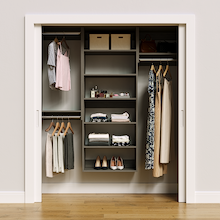 Grey 67.5-inch woodgrain Vista Total Closet Kit, front view in a reach-in closet, holding dresses