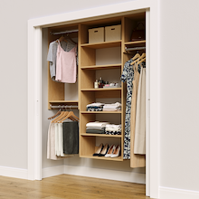 Natural oak 67.5-inch woodgrain Vista Total Closet Kit in a reach-in closet with dresses, shoes, and handbags