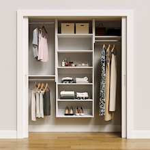 White 67.5-inch Vista Total Closet Kit, front view in a reach-in closet, holding dresses