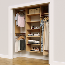 Natural oak 70.5-inch woodgrain Vista Total Closet Kit in a reach-in closet with dresses, shoes, and handbags