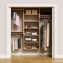 Natural oak 70.5-inch woodgrain Vista Total Closet Kit, front view in a reach-in closet, holding dresses