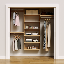 Natural oak 73.5-inch woodgrain Vista Total Closet Kit, front view in a reach-in closet, holding dresses