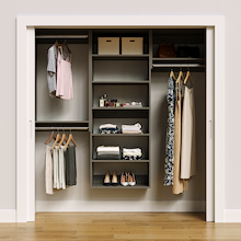 Grey 76.5-inch woodgrain Vista Total Closet Kit, front view in a reach-in closet, holding dresses