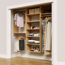 Natural oak 79.5-inch woodgrain Vista Total Closet Kit in a reach-in closet with dresses, shoes, and handbags