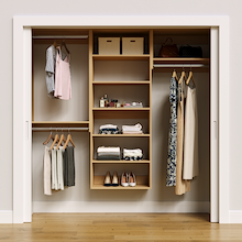 Natural oak 79.5-inch woodgrain Vista Total Closet Kit, front view in a reach-in closet, holding dresses