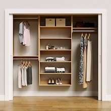 Natural oak 85.5-inch woodgrain Vista Total Closet Kit, front view in a reach-in closet, holding dresses