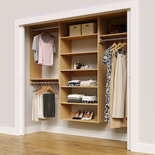 Natural oak 88.5-inch woodgrain Vista Total Closet Kit in a reach-in closet with dresses, shoes, and handbags