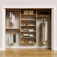 Natural oak 94.5-inch woodgrain Vista Total Closet Kit, front view in a reach-in closet, holding dresses