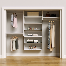 White 94.5-inch Vista Total Closet Kit, front view in a reach-in closet, holding dresses