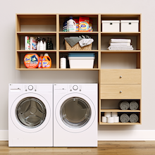 Natural Oak Choice Laundry Kit featuring built-in drawer storage and upper shelves installed above a washer and dryer to organize everyday laundry essentials.