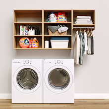 Natural Oak Classic Laundry Kit featuring laundry hanging storage and overhead shelves installed above a washer and dryer to organize everyday laundry essentials.