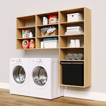 Natural Oak Select Laundry Kit with a shelf tower with a pull-out hamper and overhead shelving installed above a washer and dryer for organized laundry room storage.