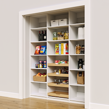 White 69 inch bulk pantry shelves with four wood pull-out drawers.