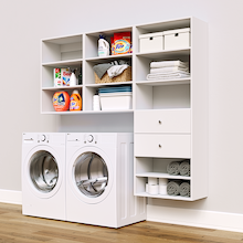 White Choice Laundry Kit with a shelf tower with two drawers and overhead shelving installed above a washer and dryer for organized laundry room storage.