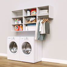 White Classic Laundry Kit with a hanging rod and overhead shelving installed above a washer and dryer for organized laundry room storage.