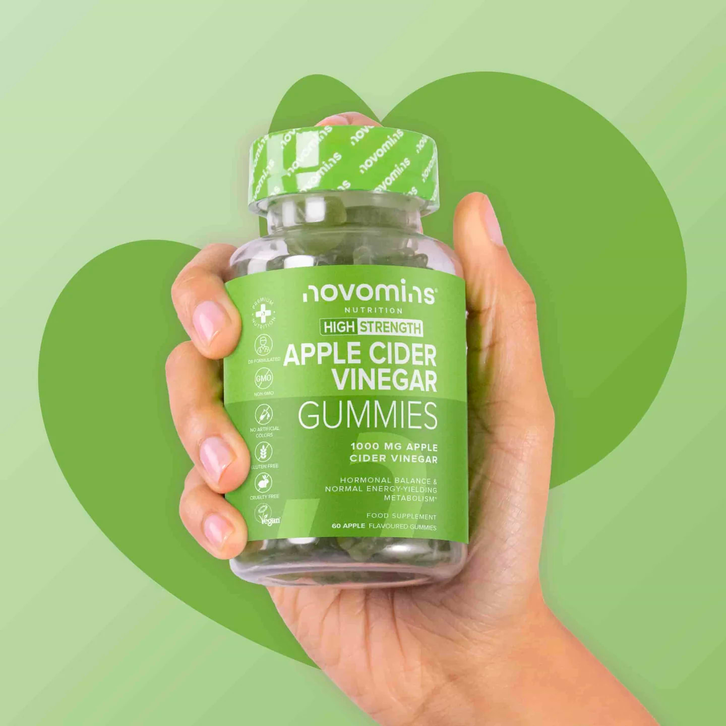 Hand holding a bottle of Novomins ACV Gummies