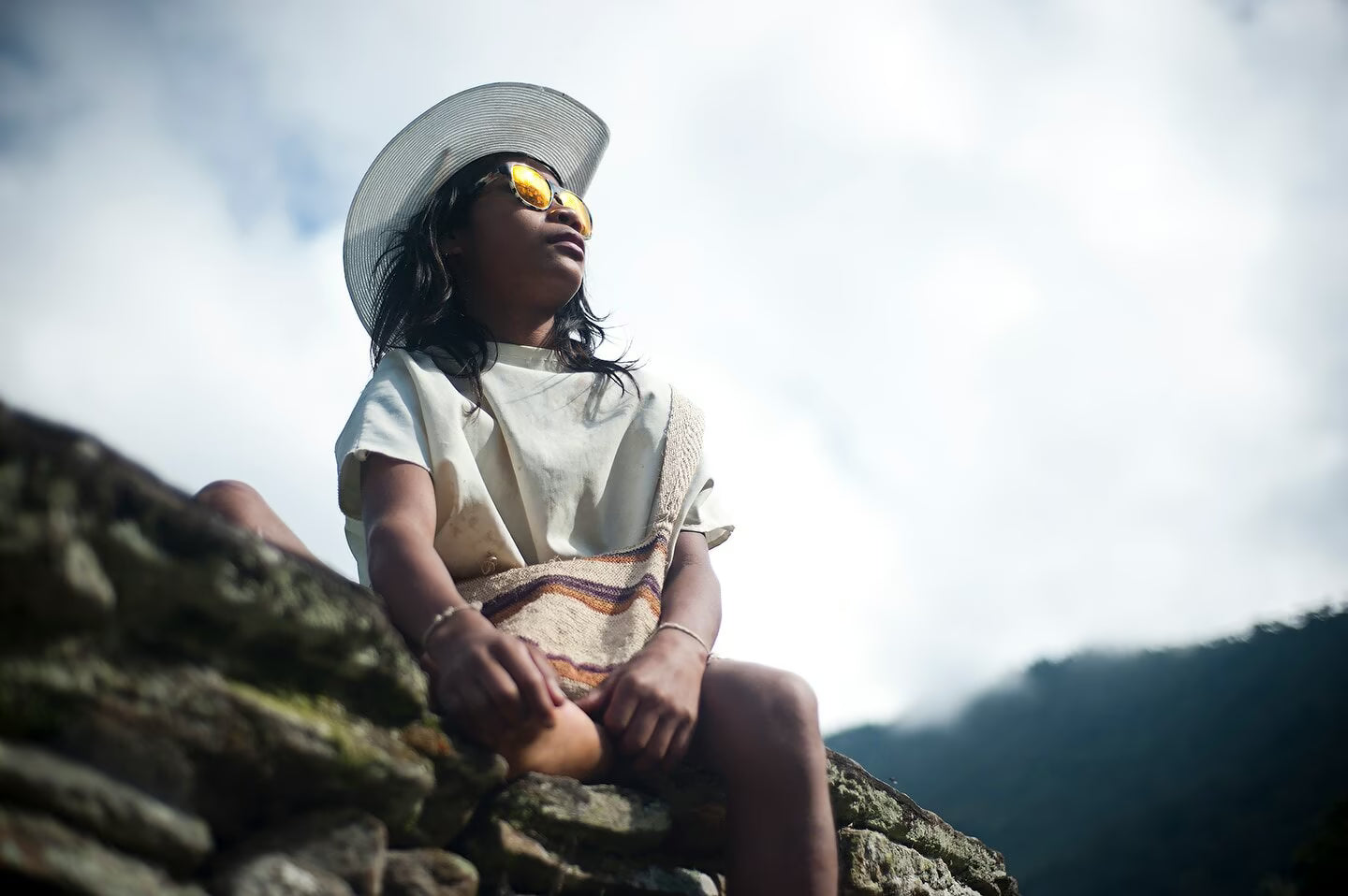 Ein kleines Mädchen mit Sonnenbrille schaut nach oben