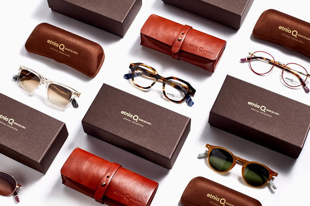 Collection of sunglasses and brown boxes with Etnia branding on a white background