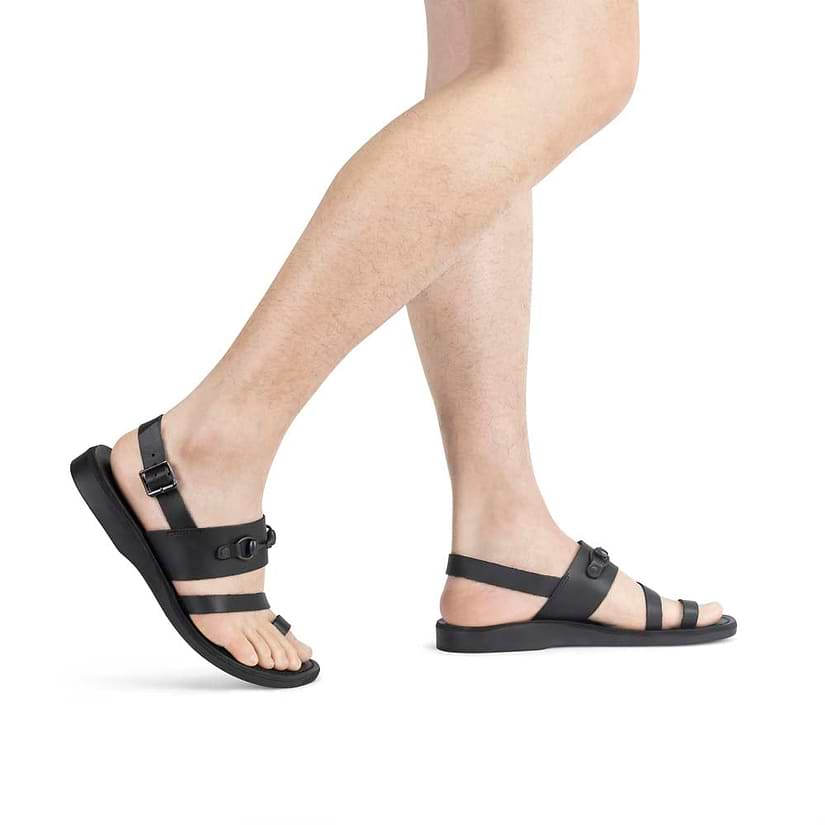 Model wearing Eliphaz black, handmade leather sandals with back strap and toe loop